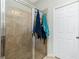 Shower room with tiled walls and glass door, complemented by towels and a white door at 2628 Sherman Oak Dr, North Port, FL 34289