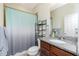 Bright bathroom featuring granite countertops and a shower with a decorative ombre curtain at 2628 Sherman Oak Dr, North Port, FL 34289