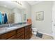 Bathroom featuring double sink vanity, granite countertop, and a framed mirror at 2628 Sherman Oak Dr, North Port, FL 34289