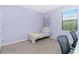 Cozy bedroom showcasing a twin bed, serene purple walls, and a sunlit window for a calm retreat at 2628 Sherman Oak Dr, North Port, FL 34289