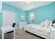 Light-filled bedroom with bright blue walls, a white bed, desk, and ample closet space at 2628 Sherman Oak Dr, North Port, FL 34289