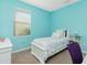 Bright bedroom featuring blue walls, a white bed, and a window with blinds at 2628 Sherman Oak Dr, North Port, FL 34289