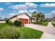 Well-maintained single-Gathering home with a brick driveway, lush lawn, and vibrant landscaping at 2628 Sherman Oak Dr, North Port, FL 34289