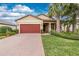 Charming single Gathering home boasting a two-car garage, manicured lawn and mature palm trees at 2628 Sherman Oak Dr, North Port, FL 34289
