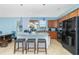 Open kitchen featuring a granite island with seating, wood cabinets and stainless steel appliances at 2628 Sherman Oak Dr, North Port, FL 34289