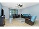 Bright living room with leather seating, ceiling fan, and access to the patio at 2628 Sherman Oak Dr, North Port, FL 34289