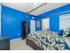 Main bedroom featuring a four-poster bed, blue walls, and a door leading to the bathroom at 2628 Sherman Oak Dr, North Port, FL 34289