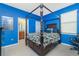 Spacious main bedroom with a four-poster bed, blue walls, and an ensuite bathroom at 2628 Sherman Oak Dr, North Port, FL 34289