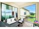 Cozy screened-in patio featuring comfortable seating, brick flooring, and access to the indoor living space at 2628 Sherman Oak Dr, North Port, FL 34289