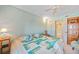 Bright bedroom featuring a queen bed with charming coastal-themed quilt and a ceiling fan at 2727 N Beach Rd # 113, Englewood, FL 34223