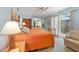 Sunlit main bedroom with balcony, mirrored closet, and comfortable seating area at 2727 N Beach Rd # 113, Englewood, FL 34223