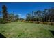 View of the spacious backyard with a lush green lawn, surrounded by trees and vegetation at 3284 Newmark St, North Port, FL 34291