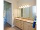 Bathroom featuring double sinks, a large mirror with lighting and a separate toilet room at 3284 Newmark St, North Port, FL 34291