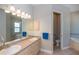 Bathroom featuring double sinks, a large mirror with lighting and a separate toilet room at 3284 Newmark St, North Port, FL 34291