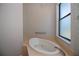 Bright bathroom showcases an inviting soaking tub beneath a window with a chrome faucet and handle at 3284 Newmark St, North Port, FL 34291