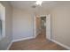 Bedroom with neutral walls, light wood flooring, ceiling fan, and view to the living area at 3284 Newmark St, North Port, FL 34291