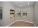 Bright bedroom featuring three windows with natural light and wood-look flooring at 3284 Newmark St, North Port, FL 34291