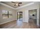Spacious bedroom with wood-look flooring, tray ceiling, and access to the patio and kitchen at 3284 Newmark St, North Port, FL 34291