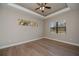 Bedroom with tray ceiling, wood-look flooring and windows providing ample natural light at 3284 Newmark St, North Port, FL 34291