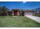 Charming single-story home featuring a stone facade and well-manicured lawn at 3284 Newmark St, North Port, FL 34291