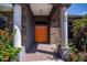 Inviting entryway with stone accents, pillars, and a vibrant orange front door at 3284 Newmark St, North Port, FL 34291