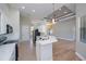 Well-lit kitchen featuring white cabinets, an island with sleek countertops, and stainless steel appliances at 3284 Newmark St, North Port, FL 34291