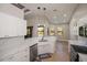 Bright kitchen with white cabinets, stainless appliances, and a sleek countertop and view to the living area at 3284 Newmark St, North Port, FL 34291