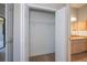 Walk-in closet with white wire shelving leading to bright bathroom with wooden cabinets and neutral vanity at 3284 Newmark St, North Port, FL 34291