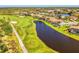 An aerial shot shows a golf course community with a pond winding through it at 3574 Pennyroyal Rd, Port Charlotte, FL 33953