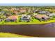 An aerial shot shows a beautiful community with single Gathering homes surrounding a pond at 3574 Pennyroyal Rd, Port Charlotte, FL 33953