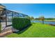 Beautiful backyard featuring well-maintained landscaping, lush green grass, and scenic water views at 3574 Pennyroyal Rd, Port Charlotte, FL 33953