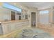 Luxury bathroom featuring dual vanities, a soaking tub, and a walk-in shower at 3574 Pennyroyal Rd, Port Charlotte, FL 33953
