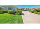 The exterior showcases a nicely landscaped front yard with a brick-paved driveway leading up to the charming home at 3574 Pennyroyal Rd, Port Charlotte, FL 33953