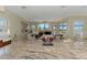 Granite kitchen island with stylish seating and views of the living room with fireplace at 3574 Pennyroyal Rd, Port Charlotte, FL 33953