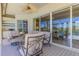 Relaxing covered lanai with comfortable seating and outdoor kitchen overlooking a serene pool and landscaped backyard at 3574 Pennyroyal Rd, Port Charlotte, FL 33953