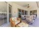 Inviting outdoor lanai with comfortable seating, ceiling fan, and view through sliding glass doors at 3574 Pennyroyal Rd, Port Charlotte, FL 33953