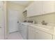 Laundry room featuring washer, dryer, sink, tile floor, and overhead cabinet at 3574 Pennyroyal Rd, Port Charlotte, FL 33953