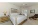 Bright and airy main bedroom featuring a four-poster bed, a ceiling fan, and a sitting area at 3574 Pennyroyal Rd, Port Charlotte, FL 33953