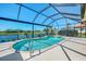Inviting screened pool with water views, surrounded by a spacious patio and manicured landscaping at 3574 Pennyroyal Rd, Port Charlotte, FL 33953