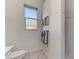Cozy bathroom highlighting the commode, small window and tiled shower at 3615 Pennyroyal Rd, Port Charlotte, FL 33953