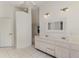 Bright bathroom featuring double sinks, decorative mirror, and tiled shower at 3615 Pennyroyal Rd, Port Charlotte, FL 33953
