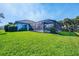 Home exterior featuring a screened-in pool area and a lush green lawn at 3615 Pennyroyal Rd, Port Charlotte, FL 33953