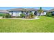 Charming single-story home with arched windows, complemented by vibrant landscaping at 3615 Pennyroyal Rd, Port Charlotte, FL 33953