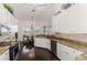 Open-concept kitchen features stainless steel appliances, granite counters, white cabinets, and views of the outdoor space at 3615 Pennyroyal Rd, Port Charlotte, FL 33953