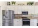 Bright kitchen featuring stainless steel appliances, granite countertops, and white cabinets with stylish decor at 3615 Pennyroyal Rd, Port Charlotte, FL 33953