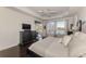 Main bedroom featuring hardwood floors, tray ceiling, a lake view, and a sliding door entrance to the lanai at 3615 Pennyroyal Rd, Port Charlotte, FL 33953