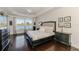 Main bedroom with hardwood floors, a tray ceiling, dark furniture and a picturesque lake view at 3615 Pennyroyal Rd, Port Charlotte, FL 33953