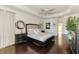 Comfortable main bedroom boasts hardwood floors, tray ceiling, large windows, and dark wood furniture at 3615 Pennyroyal Rd, Port Charlotte, FL 33953