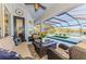 Inviting outdoor living space with a seating area, screened lanai, pool, and a serene lake view at 3615 Pennyroyal Rd, Port Charlotte, FL 33953