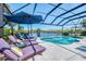 Relaxing poolside with comfortable lounge chairs and umbrellas, offering stunning water views at 3615 Pennyroyal Rd, Port Charlotte, FL 33953